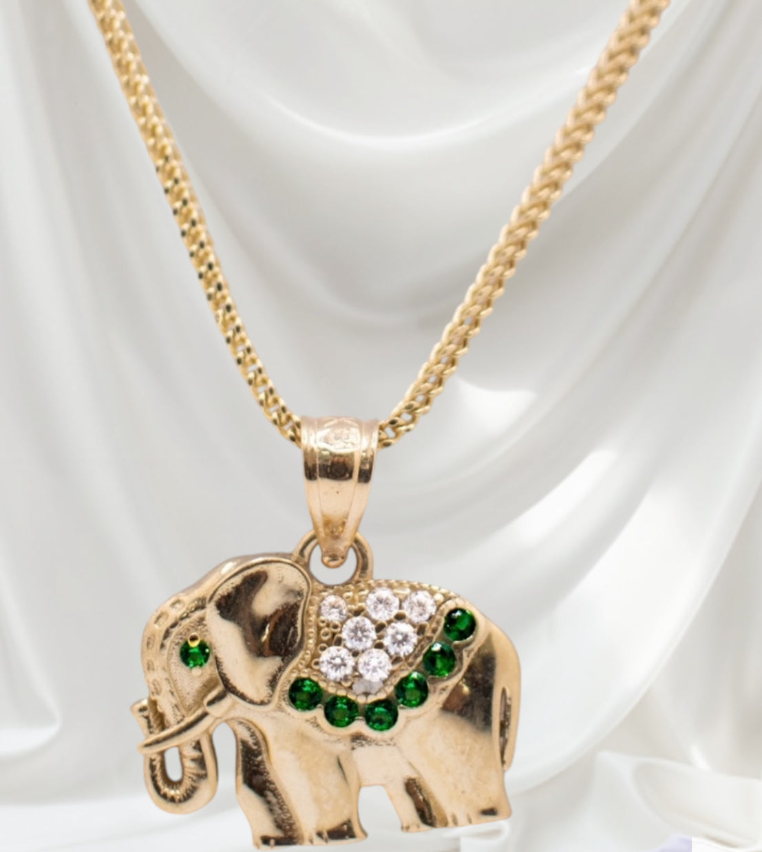 Majestic elephant pendant with green stones paired with a necklace